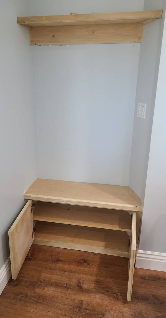 The entry bench with its doors open, showing a shelf and concealed hinges