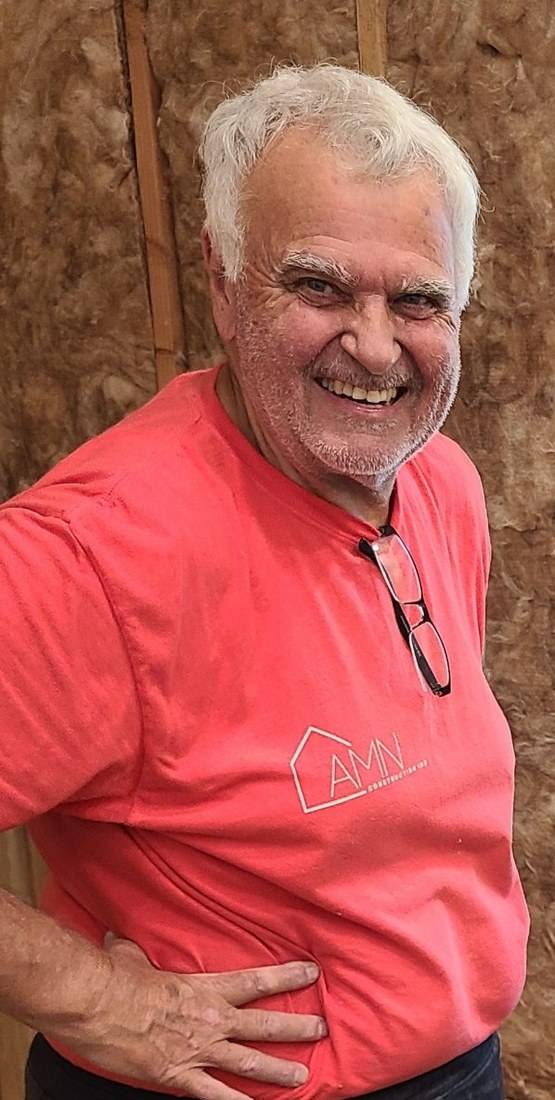 Tom, the finish carpenter, smiling in an AMN Construction shirt